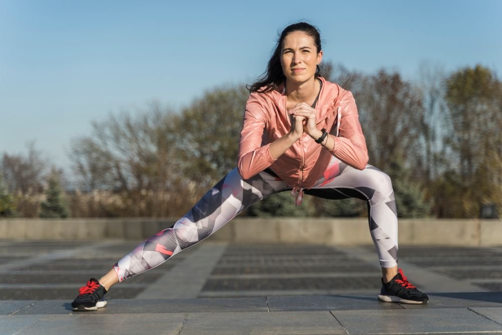 Menopausa: Como evitar a perca de massa óssea, controlar o peso e ganhar vitalidade com Exercício Físico mulher praticando exercício físico com agachamento com passos laterais
