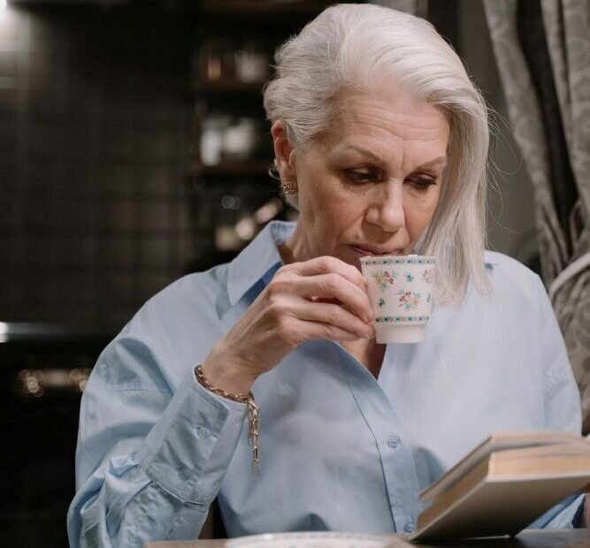 O-Estilo-da-Mulher-Madura-mulher-elegante-tomando-cafe-enquanto-le.jpg