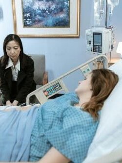 mulher 50 mais observando paciente em leito de hospital em que trabalha como cuidadora