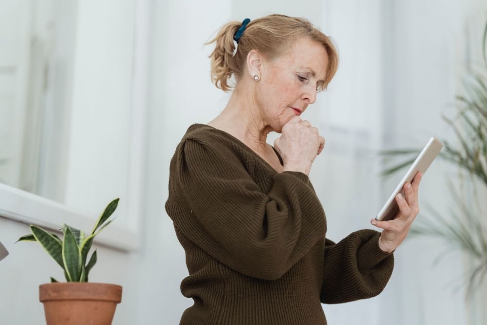 mulher madura lendo em um tablet , assunto curioso, o que leva a fazer-se questionamentos sobre o tema